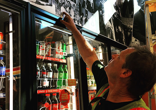 A picture of owner pointing to family picture on the wall